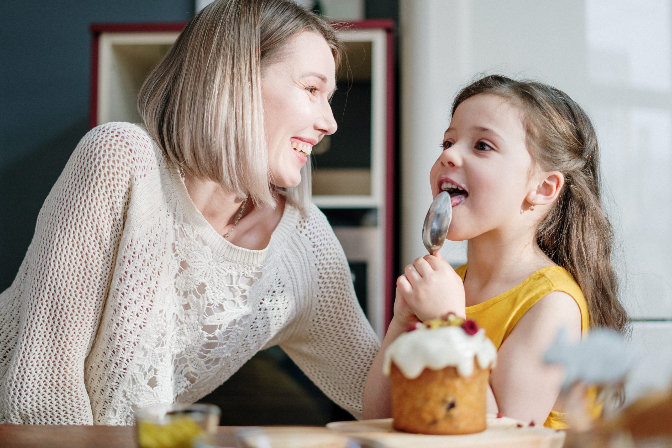 Mother and daughter smiling and eating desserts